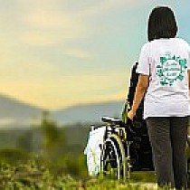 zdjęcie ilustracyjne - osoba na wózku prowadzona przez osobę pełnosprawną